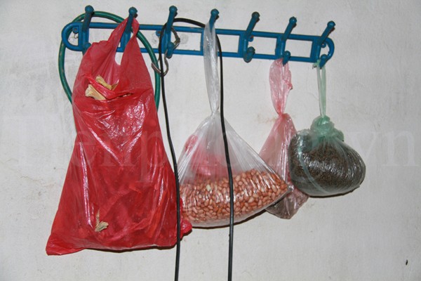 Túi lạc, thức ăn dự trữ được treo trên tường, phía trên bếp gas. Ảnh: Trường Phong
