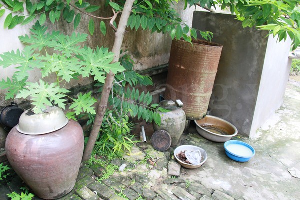 Những chiếc chum đựng nước vẫn được tận dụng, bên cạnh một bể nước mới được xây dựng. Ảnh: Trường Phong