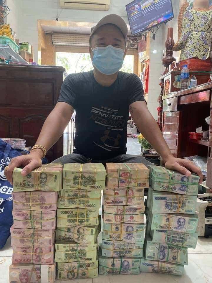  
Nam thanh niên bên cạnh chồng tiền được cho là trúng xổ số. (Ảnh: FB Đ.H.S)